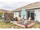 Charming backyard patio with a dining set, grill, and a privacy fence decorated with outdoor ornaments at 1907 Myakka Ct, Poinciana, FL 34759