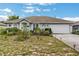 Charming single-story home with a two-car garage and lush garden in the front yard at 1907 Myakka Ct, Poinciana, FL 34759