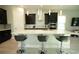 Modern kitchen features sleek black cabinets, stainless steel appliances, and a large quartz island with seating at 2035 White Feather Loop, Oakland, FL 34787