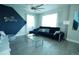 Stylish living room with a modern ceiling fan, two windows, a dark couch, and hardwood floors at 2035 White Feather Loop, Oakland, FL 34787