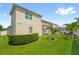 Well-maintained backyard featuring lush green grass, a hedge, palm trees, and a screened-in porch at 2051 Sandy Garden Ln, Winter Garden, FL 34787