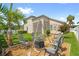 Backyard with a custom fire pit, seating, lush landscaping, a mature palm tree and privacy fencing at 2051 Sandy Garden Ln, Winter Garden, FL 34787