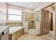 Well-lit bathroom featuring a glass shower and large soaking tub for a luxurious and relaxing experience at 2051 Sandy Garden Ln, Winter Garden, FL 34787