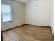 Bright bedroom with wood-look floors, and large window with blinds, offering a serene and comfortable space at 2051 Sandy Garden Ln, Winter Garden, FL 34787