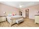 An inviting primary bedroom boasts neutral tones, wood floors, and a sitting bench at the foot of the bed at 2051 Sandy Garden Ln, Winter Garden, FL 34787