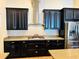 Gourmet kitchen featuring stainless steel appliances, granite countertops, dark cabinets, and modern fixtures at 2051 Sandy Garden Ln, Winter Garden, FL 34787