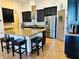 Modern kitchen featuring a large island with bar seating, stainless steel appliances, and sleek, dark cabinetry at 2051 Sandy Garden Ln, Winter Garden, FL 34787
