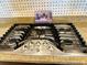 Close-up of stainless steel gas stovetop with granite countertops, designed for cooking and meal preparation at 2051 Sandy Garden Ln, Winter Garden, FL 34787