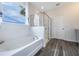 Bright bathroom with a soaking tub and a glass-enclosed shower, framed by a large window at 2068 Ashwood Bluff Dr, Ocoee, FL 34761