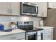 Modern kitchen features stainless steel appliances, gray cabinets, and white subway tile backsplash at 2068 Ashwood Bluff Dr, Ocoee, FL 34761