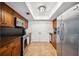 Well-lit kitchen with stainless steel appliances, wood cabinets, and sleek black backsplash at 211 Crown Oaks Way # 205, Longwood, FL 32779