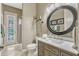 Chic bathroom features modern fixtures and a large round mirror at 213 N Monterey Isle, Longwood, FL 32779