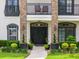 Up close view of the double door entry, landscaping, and balcony highlighting the home's curb appeal at 213 N Monterey Isle, Longwood, FL 32779