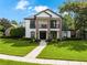 Elegant two-story home featuring a walkway to the front door, a well-manicured lawn, and mature trees at 213 N Monterey Isle, Longwood, FL 32779
