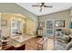 Bright living room features hardwood floors, a ceiling fan, and an open layout into the foyer at 213 N Monterey Isle, Longwood, FL 32779