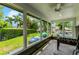 Enclosed sunroom featuring tile flooring, a ceiling fan, and multiple windows with views of the lush backyard at 213 N Monterey Isle, Longwood, FL 32779