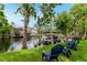 Waterfront view with boat dock and lush green lawn with shady trees at 213 N Monterey Isle, Longwood, FL 32779