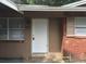 The home's front entrance is marked with a white door, flanked by windows and classic red brick at 2260 Willie Mays Pkwy, Orlando, FL 32811