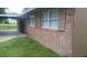 This exterior shot reveals a charming red brick home with shuttered windows, and a quaint carport at 2260 Willie Mays Pkwy, Orlando, FL 32811