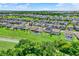 Wide aerial shot of a neighborhood with spacious yards, and mature trees under a sunny sky at 2390 Standing Rock Cir, Oakland, FL 34787