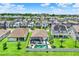 Aerial view of the backyard featuring a screened pool, patio, manicured lawn, and neighborhood at 2390 Standing Rock Cir, Oakland, FL 34787