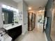 Bathroom featuring a walk-in shower with black trim and neutral-colored stone countertops at 2390 Standing Rock Cir, Oakland, FL 34787