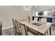 Elegant dining room featuring a modern table with integrated burners, stylish chairs, and views into the living space at 2390 Standing Rock Cir, Oakland, FL 34787