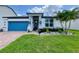 Charming single-story home with a blue garage door, stone accents, and beautifully landscaped front yard at 2390 Standing Rock Cir, Oakland, FL 34787
