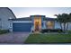 Charming single-story home with a blue garage door, stone accents, and beautifully landscaped front yard at 2390 Standing Rock Cir, Oakland, FL 34787