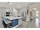 Bright kitchen featuring a spacious island with seating, stainless steel appliances, and wood-look tile flooring at 2390 Standing Rock Cir, Oakland, FL 34787