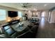 Spacious living room with modern furnishings, a large TV, and an open layout connecting to the kitchen at 2390 Standing Rock Cir, Oakland, FL 34787