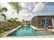 Inviting in-ground pool featuring a screened enclosure, surrounded by lush landscaping and seating areas at 2390 Standing Rock Cir, Oakland, FL 34787