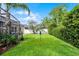 Green backyard featuring a screened-in porch, lush landscaping, and well-maintained lawn creating a peaceful outdoor retreat at 2418 Ridgemooor Dr, Orlando, FL 32828