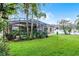 Green backyard featuring a screened-in porch, lush landscaping, and well-maintained lawn that create a private oasis at 2418 Ridgemooor Dr, Orlando, FL 32828