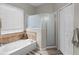 Inviting bathroom featuring a corner soaking tub, a glass enclosed shower and tile flooring for a spa-like experience at 2418 Ridgemooor Dr, Orlando, FL 32828