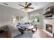 Inviting living room with a fireplace, wood floors, large windows that bring in light, and comfortable sectional couch at 2418 Ridgemooor Dr, Orlando, FL 32828