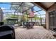 Screened patio with comfortable seating, a table for dining, and a grill, perfect for outdoor entertaining at 2418 Ridgemooor Dr, Orlando, FL 32828
