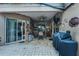 Charming covered patio featuring brick pavers, a ceiling fan, mini fridge, grill and tasteful decor for outdoor living at 2418 Ridgemooor Dr, Orlando, FL 32828