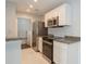 Modern kitchen featuring stainless steel appliances, granite countertops, and white cabinets at 2501 Grassy Point Dr # 107, Lake Mary, FL 32746