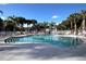 A beautiful community pool with sun loungers and plenty of palm trees for shade on a sunny day at 2501 Grassy Point Dr # 107, Lake Mary, FL 32746