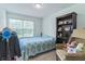 Bright bedroom with a cozy armchair, built-in bookshelf, and a window at 3028 Water Sprite St, Orlando, FL 32808