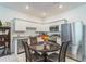 Cozy kitchen with white cabinets, stainless steel appliances, granite counters, and a central round table at 3028 Water Sprite St, Orlando, FL 32808