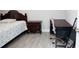 Bedroom with wood-look tile floor features a wooden headboard bed and desk at 309 E 13Th St, Apopka, FL 32703