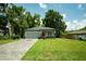 Single-story home with gray exterior, brick driveway, and green lawn at 309 E 13Th St, Apopka, FL 32703