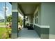 Covered front porch with gray brick columns and clean concrete flooring offers a welcoming entrance at 309 E 13Th St, Apopka, FL 32703