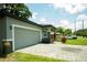 Side view showing the gray exterior with a garage and brick driveway at 309 E 13Th St, Apopka, FL 32703