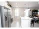Well-lit kitchen with stainless steel appliances, white cabinets, and kitchen island at 309 E 13Th St, Apopka, FL 32703