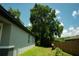 Exterior view of side yard with lush tree and landscaping at 309 E 13Th St, Apopka, FL 32703