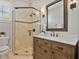 This bathroom features a glass shower, wood vanity, and a framed mirror at 3535 Lake Sarah Dr, Orlando, FL 32804