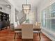 Dining room features wood floors, modern light fixture, stylish artwork, and large windows at 3535 Lake Sarah Dr, Orlando, FL 32804